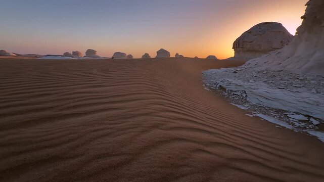 Wind shaped sand patterns in Sahara desert at sunset. Cinematic close up pull forward motion