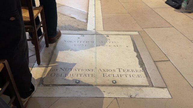Famous astronomical gnomon of the Church of Saint-Sulpice in Paris, France, with its brass meridian line crossing the marble plaque indicating the summer solstice and earth's axial tilt