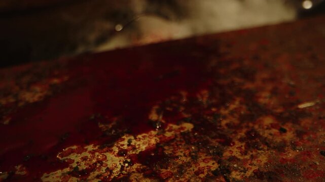 Horror concept: Stunning macro dolly of a blood covered saw with sharp teeth in a dark room