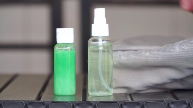 Hand placing hand sanitizer and soap into a bag. Hygiene and travel essentials concept, perfect for health, cleanliness, and personal care stock footage.