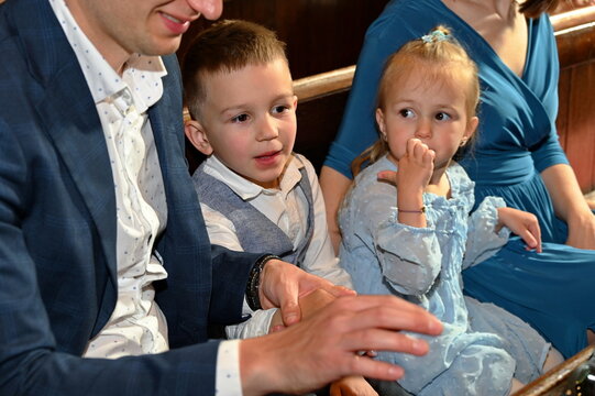 Family with two children sitting in the church during wedding ceremony