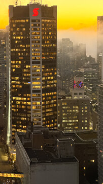 Vancouver , Canada - January 2026: Scotiabank tower dominates foggy downtown skyline at dramatic golden sunset with illuminated office windows and neon clock sign