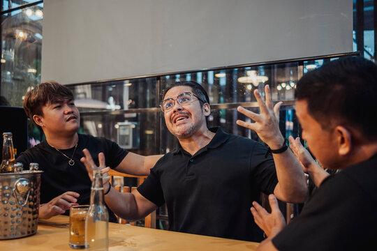 A man vents and showing emotional stress, frustration, and tension, sharing personal problems and releasing feelings through conversation while his friends is trying to calm and support him.