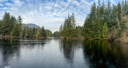 Obraz premium Frozen Rice Lake in winter with conifer forest, Lynn Canyon, North Vancouver