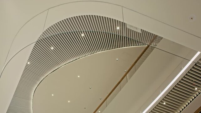 Low angle no people shot of modern commercial building ceiling with glass elements, original lighting and futuristic architectural design