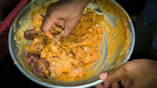 Mixing raw chicken with spices and marinade for kababs