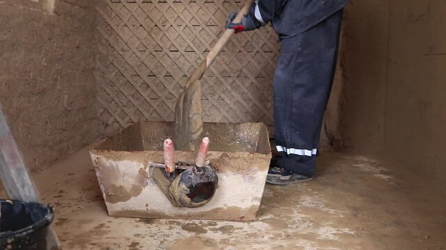 A student in a training workshop practices practical skills in preparing cement mortar.