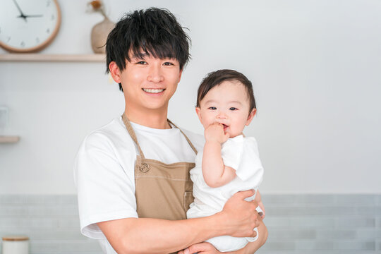 マイホームのキッチンで赤ちゃんを抱っこする父親,パパ,ベビーシッター