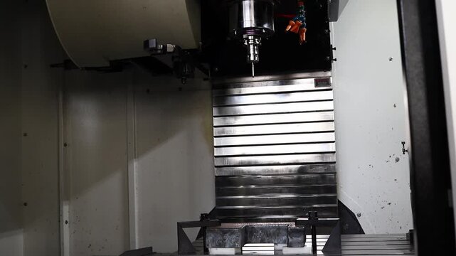 Modern automated machine tool in a production shop performs precision machining of parts in an industrial environment.