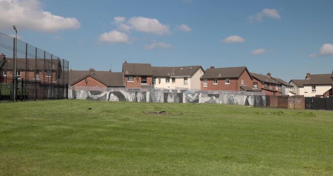 multiple murals of facial expressions on display at the Belfast Peace Wall