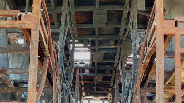 Tilt down shot inside a fire destroyed sleeper bus revealing exposed ceiling framework, rusted berth structures, charred interior and skeletal passenger compartments!