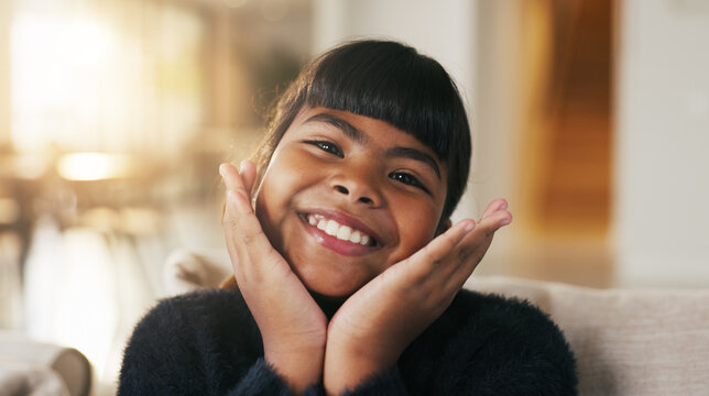 Portrait, child and face frame on couch with smile, positive attitude and childhood development. Happy, young kid and kindness in comfortable home with growth, unibrow and weekend in Philippines