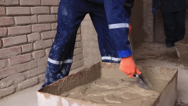 Students perform plastering work in a training workshop during a practical construction lesson.