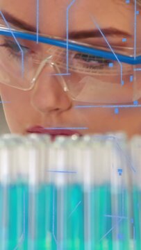 Vertical video: Scientist scanning test tubes in lab, gaze activating HUD, analyzing samples
