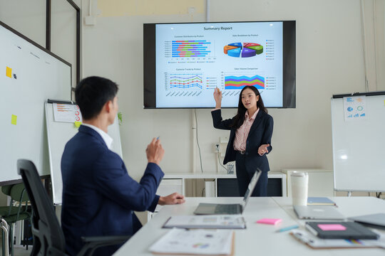 Asian business people discussing financial report during meeting