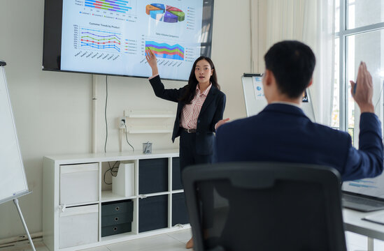 Businesswoman presenting data analysis on screen during team meeting
