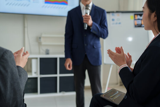 Business audience applauding speaker after successful presentation