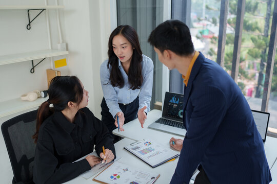 Business team analyzing data, discussing strategy in office