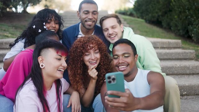 Happy group of friends using mobile smartphone sitting outside of college - Young people lifestyle concept