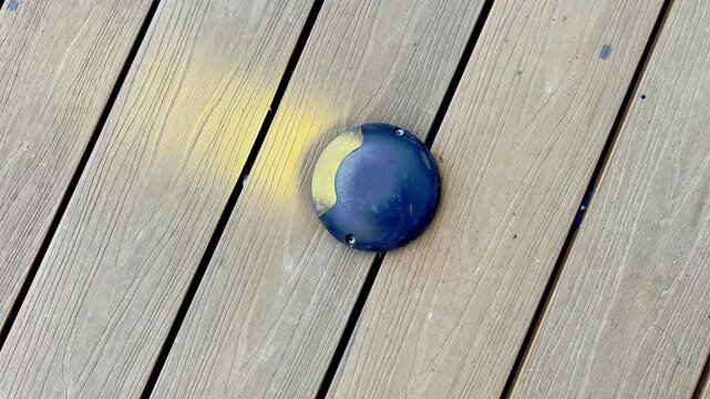 Blue object on wooden deck near shadow