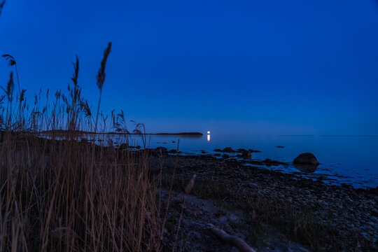 Moonrise over Water near Vilm Island on R&uuml;gen with Reeds and Boulder Stones in Foreground