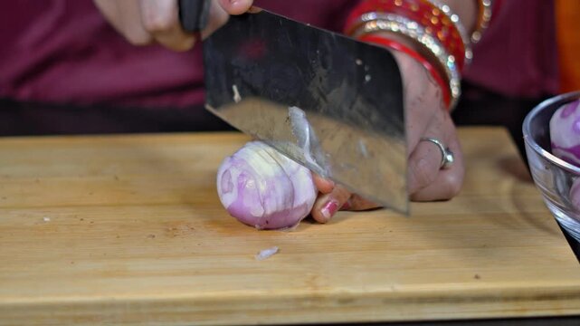 Slicing raw organic onion with large chopper blade on cutting board