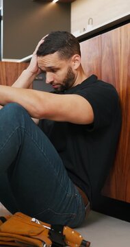 Tired, man and plumber with stress at house for plumbing fail, burst pipe crisis and repair disaster. Fatigue, male person and technician with burnout, maintenance mistake and water system issues