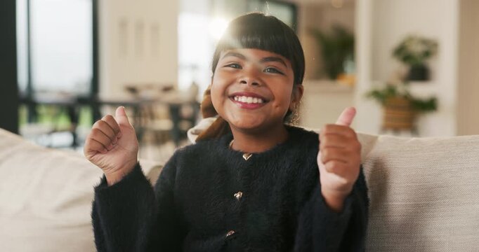 Cute, face and thumbs up with girl child on sofa in home living room for development or growth. Adorable, future and success with happy kid on couch in apartment for morning, relax or weekend chill