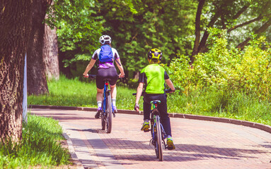 Fototapeta premium Cyclists ride on the bike path in the city Park 