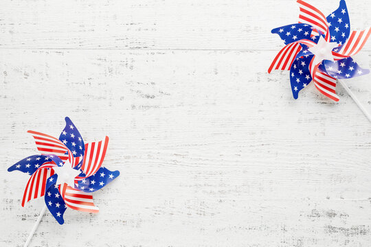 Patriotic american holiday flag pinwheels on rustic white wooden background with copy space. Festive red, white and blue design element for independence, memorial, veterans, election, labor or voting