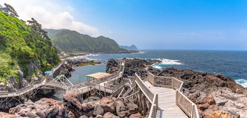 Scenic wooden boardwalk over crystal clear turquoise sea in Akasaki Promenade, Kozushima Island, Japan. © dah_keni