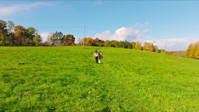 Drone follows two women walking in Embute parish South Kurzeme slow motion