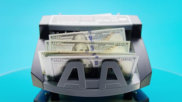 Cash Counter Machine Counting Dollar Bills on Blue