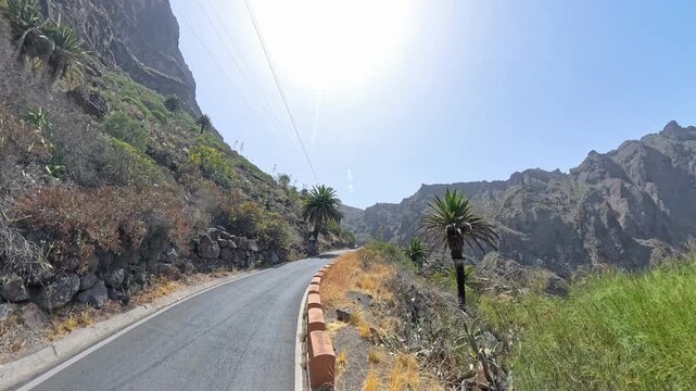Driving on mountain serpentine road TF-436 in Masca Valley, Tenerife, Canary Islands, sunny scenic route with lens flare, shot on 360 camera 