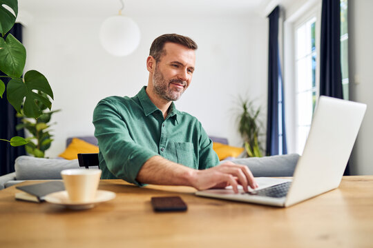 Business working with laptop from home sitting at table