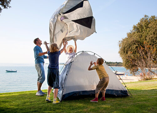 Croatia, Zadar, Family putting up tent at beach