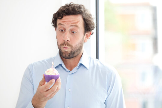 Businessman holding birthday cupcake
