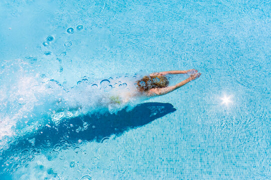 Spain, woman diving in swimming pool
