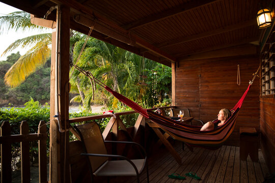 Caribbean, Trinidad and Tobago, Tobago, Castara, woman in hamock on porch