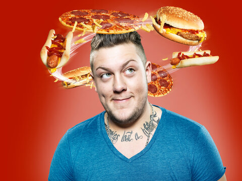 Young man with flying fast food around his head, Composite
