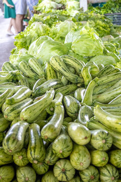 Vibrant Fresh Organic Zucchini and Lettuce Pile at Outdoor Farmers Market
