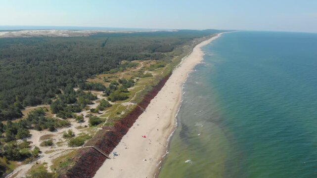 An aerial drone shot on a sunny day captures the stunning natural beauty of the Baltic Sea coastline near Klaipeda, Lithuania.