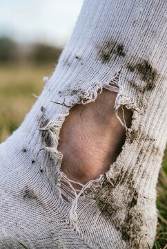 Torn soccer sock fabric with mud stains