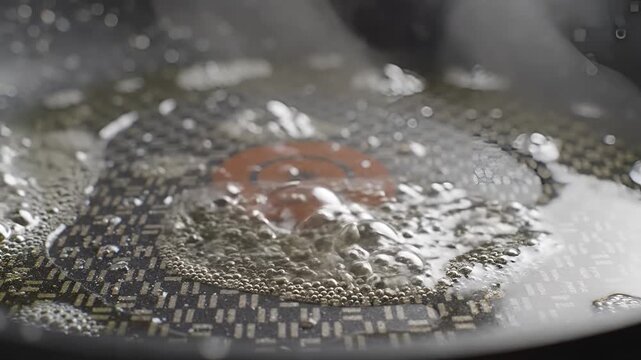 Closeup of Bubbles Forming in Boiling Water with Red Hue.