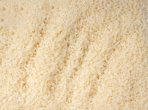 Grated coconut powder. Dry coco flakes pile, shredded desiccated coconut, tropical fruit chips