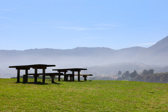 Wooden bench on viewpoint on The Island Beach, a golden sandy beach in Asturias, Spain