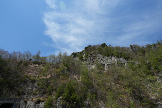 A low angle view of steep green mountains under blue sky.
