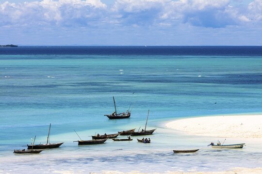 Fishing boats in turquoise green water on the beach of Kendwa, Zanzibar, Tanzania