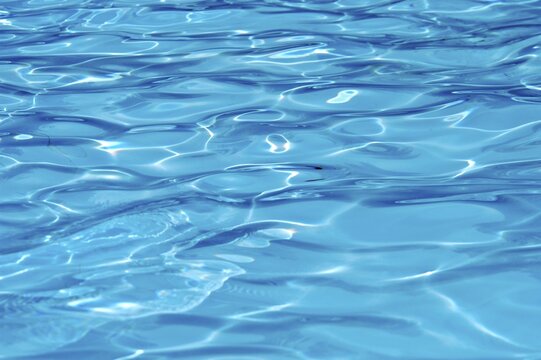 Water surface in a swimming pool with lights reflections