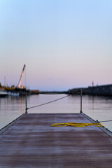 Fototapeta premium Empty wooden dock extending into serene twilight harbor
